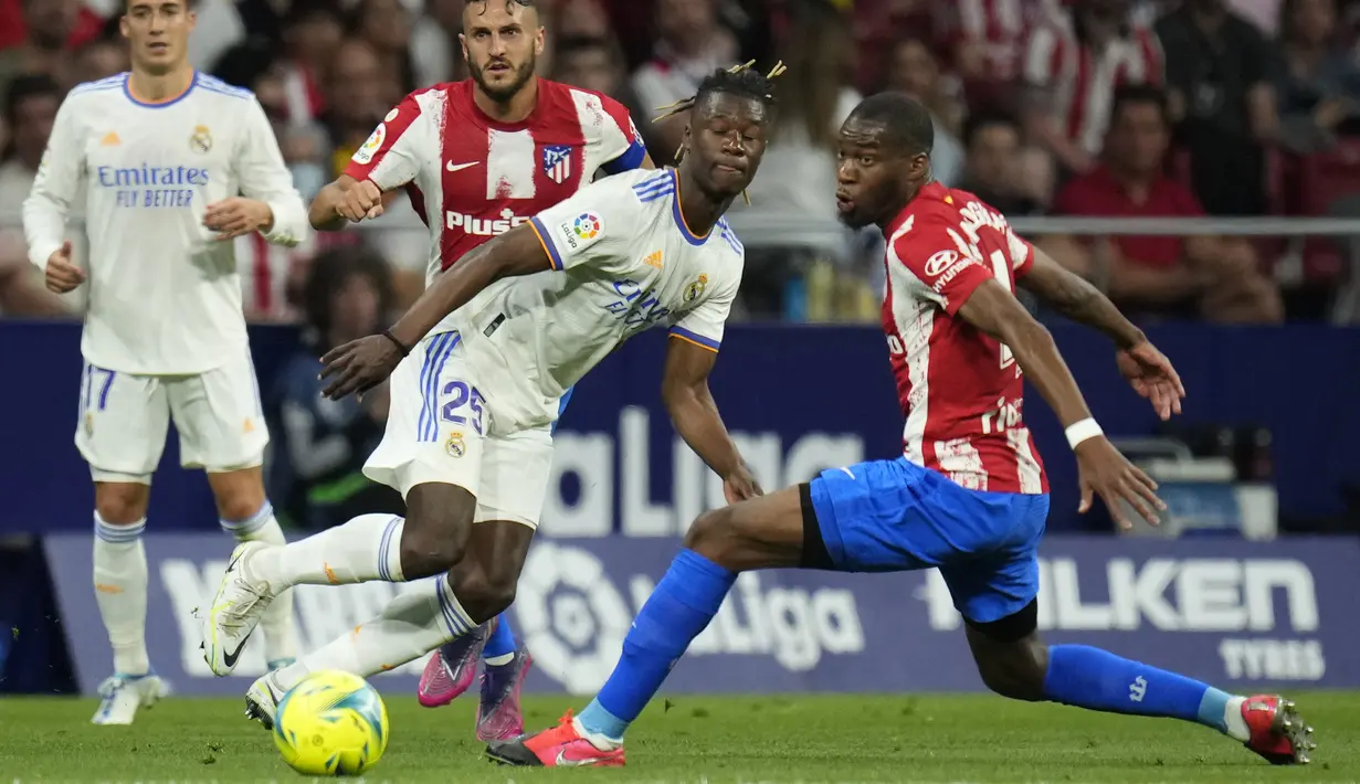 <p>Gelandang&nbsp;Atletico Madrid Geoffrey Kondogbia berebut bola dengan gelandang&nbsp;Real Madrid Eduardo Camavinga&nbsp; dengan skor tipis 1-0 atas Real Madrid. (AP Photo/Manu Fernandez)</p>