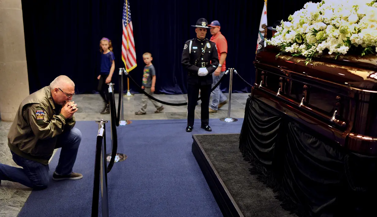 Pengunjung Steven Leslie berdoa di depan peti mati mantan Ibu Negara Nancy Reagan di Perpustakaan Kepresidenan Ronald Reagan, Simi Valley, California (9/3). Nancy Davis Reagan lahir 6 Juli 1921 di New York City. (REUTERS/Wally Skalij)