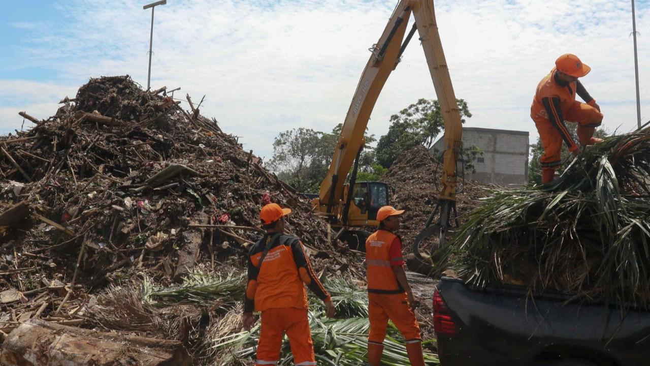 Sebuah alat berat ekskavator mengangkut sampah-sampah dari Kali Ciliwung untuk nantinya diolah ke mesin pencacah di tempat penyaringan sampah di TB Simatupang, Jakarta, Selasa (9/1/2024).