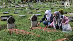 Sejumlah warga saat ziarah kubur di Tempat Pemakaman Umum (TPU) Karet Bivak, Jakarta, Senin (2/5/2022). Menyambut Hari Raya Idul Fitri 1443 H, umat Islam melakukan ziarah kubur mendoakan sanak keluarga dan kerabat yang sudah wafat. (Liputan6.com/Johan Tallo)