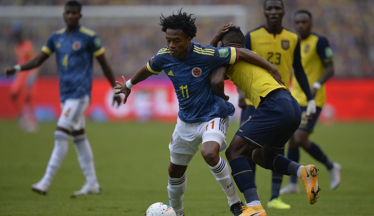 Pemain Kolombia, Juan Cuadrado (kiri), berebut bola dengan pemain Ekuador, Pervis Estupinan, dalam laga lanjutan kualifikasi Piala Dunia 2022 zona CONMEBOL melawan Ekuador di Rodrigo Paz Delgado Stadium, Quito, Ekuador, Rabu (18/11/2020) pagi WIB. Kolombia kalah 1-6.  (AFP/Rodrigo Buendia/Pool)