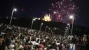 Orang-orang berkumpul di jembatan untuk menyaksikan kembang api Hari Bastille di Lyon, Prancis tengah, Jumat, 14 Juli 2023. (AP Photo/Laurent Cipriani)