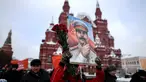 Seorang wanita membawa lukisan potret Stalin saat menghadiri upacara memperingati 65 tahun kematian pemimpin Uni Soviet Joseph Stalin di Lapangan Merah, Moskow (5/3). Stalin meninggal pada tahun 1924. (AFP/Kirill Kudryavtsev)