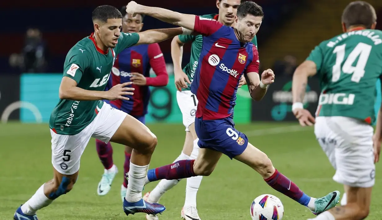 Pemain Barcelona, Robert Lewandowski, berusaha melewati pemain Alaves pada laga pekan ke-13 La Liga 2023/2024 di Estadi Olímpic Lluís Companys, Minggu (12/11/2023). Dengan kemenangan ini, Barcelona mengemas 30 angka dari 13 laga dan berada di peringkat ketiga klasemen sementara. (AP Photo/Joan Monfort)