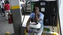Seorang pria memegang tangki bensin sepeda motornya saat menunggu di sebuah pompa bensin di Port-au-Prince, Haiti, Minggu (31/10/2021). Kelangkaan BBM membuat warga Haiti sulit mendapatkan transportasi dan memaksa sejumlah bisnis menghentikan operasi. (AP Photo/Matias Delacroix)