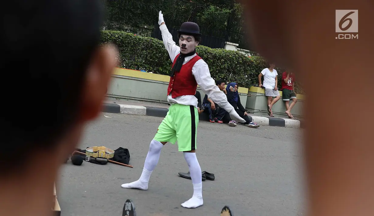 Seniman pantomim tampil menghibur pengunjung car free day di Jakarta, Minggu (1/7). Aksi tersebut dilakukan guna mengumpulkan biaya yang akan digunakan untuk menikah. (Liputan6.com/Immanuel Antonius)