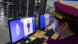 Seorang staf tengah menguji sistem pendeteksi termal untuk memeriksa suhu tubuh penumpang di area bawah tanah Stasiun Kereta Api Hankou di Wuhan, Provinsi Hubei, China tengah, pada 23 Maret 2020. Saat ini, Wuhan sedang bersiap memulihkan pengoperasian transportasi umum. (Xinhua/Xiao Yijiu)