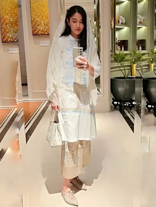 Ide OOTD anggun elegan Dian Sastrowardoyo pakai baju kurung. Melalui potret mirror selfie ini, Dian Sastro memadukan baju kurung putih dengan bordir biru muda yang cantik dengan rok cokelatnya yang serasi, dengan syal sebagai kerudung. [Foto: Instagram/therealdisastr]
