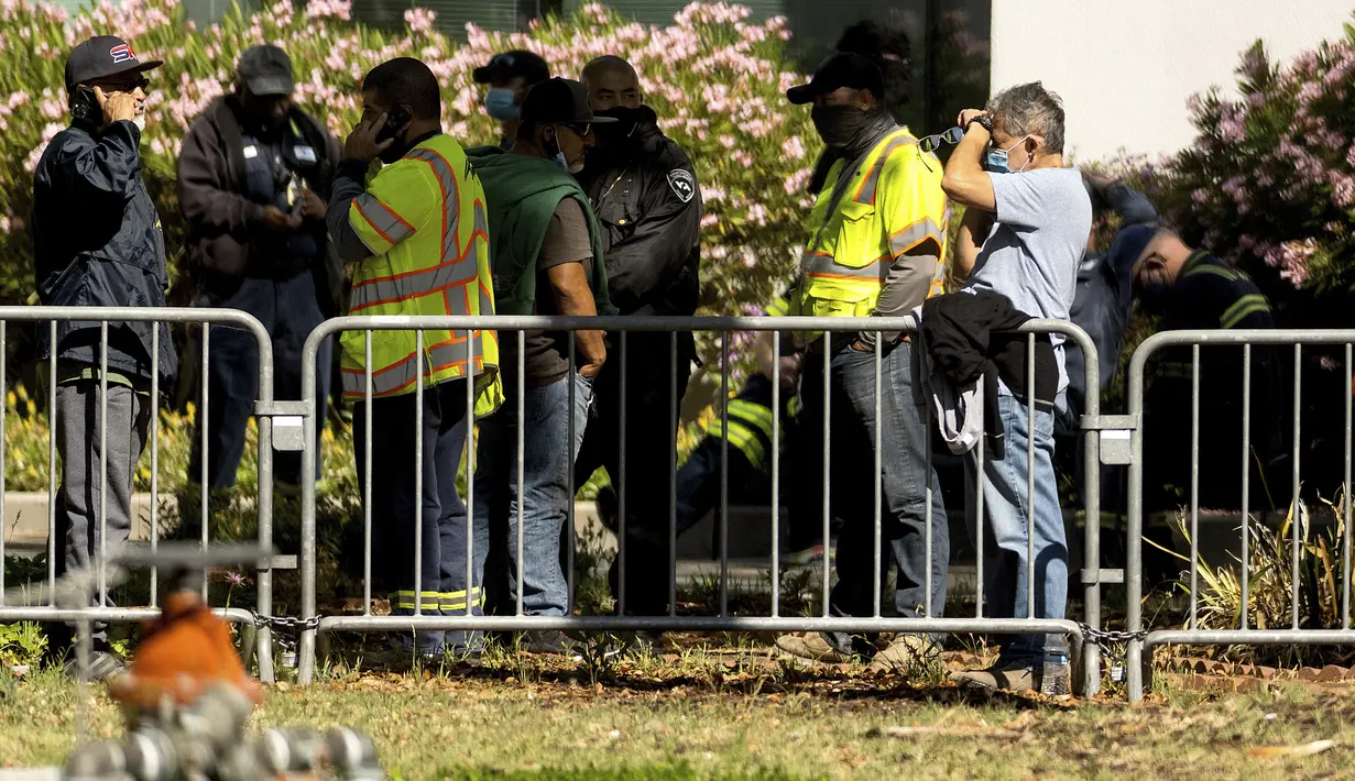 Pekerja Otoritas Transportasi Lembah Santa Clara (VTA) berkumpul di dekat railyard setelah penembakan di San Jose, California (26/5/2021). Peristiwa penembakan menewaskan  sejumlah orang. (AP Photo/Noah Berger)