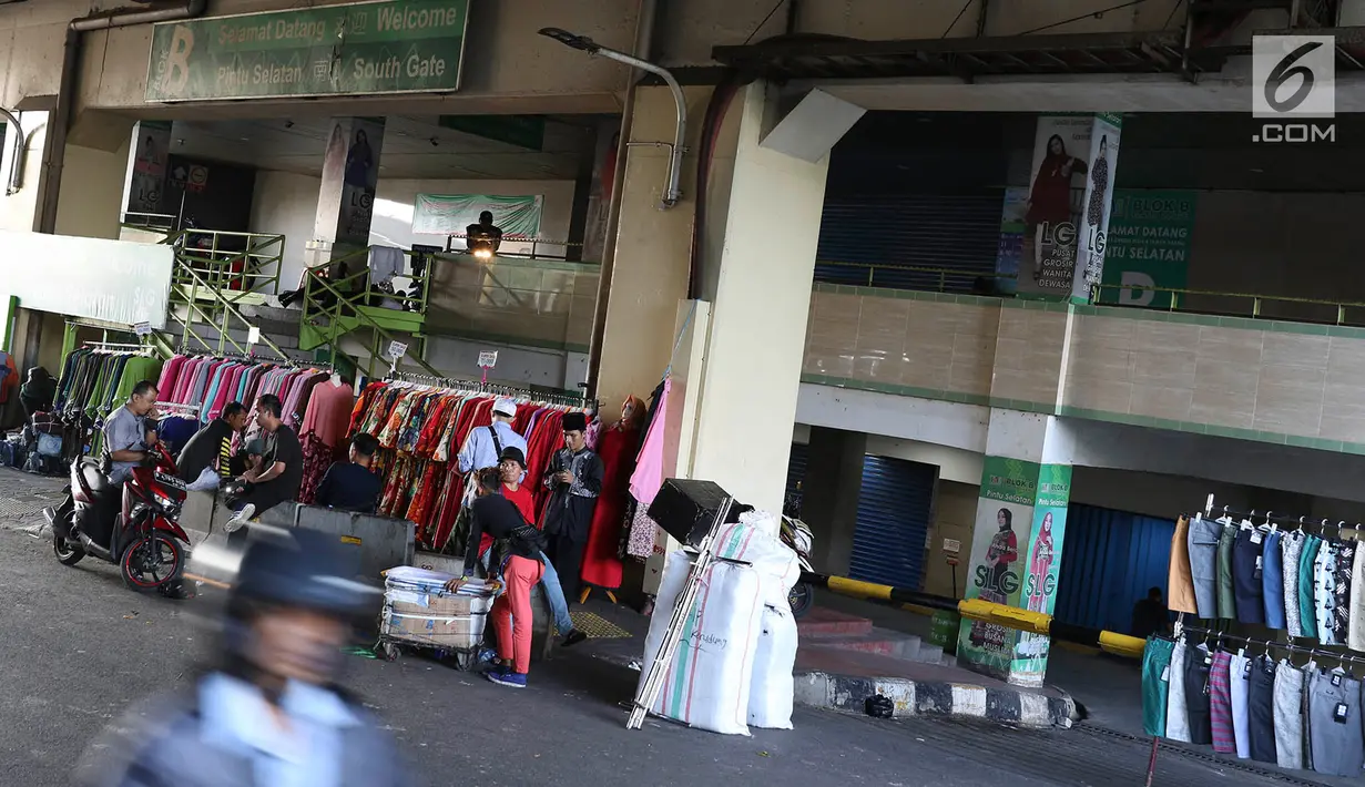 Pedagang berjualan di depan Gedung Pasar Tanah Abang, Jakarta, Jumat (22/6). Sebagian pedagang terpaksa menggelar lapak di luar gedung akibat belum dibukanya kembali Pasar Tanah Abang usai Lebaran. (Liputan6.com/Immanuel Antonius)