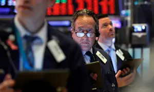Steven Kaplan (tengah) saat bekerja dengan sesama pialang di New York Stock Exchange, Amerika Serikat, Rabu (11/3/2020). Bursa saham Wall Street anjlok karena investor menunggu langkah agresif pemerintah AS atas kejatuhan ekonomi akibat virus corona COVID-19. (AP Photo/Richard Drew)