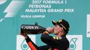 Pembalap Red Bull asal Belanda, Max Verstappen merayakan kemenangan dengan minum sampanye di podium setelah menjuarai Formula 1 Grand Prix Malaysia di Sepang, Minggu (01/10) (AFP PHOTO / MANAN VATSYAYANA)