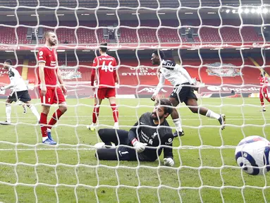 Penjaga gawang Liverpool Alisson gagal menyelamatkan gawangnya dari tendangan pemain Fulham Mario Lemina pada pertandingan Liga Inggris di Stadion Anfield, Liverpool, Inggris, Minggu (7/3/2021). Liverpool takluk 0-1 dari Fulham. (Phil Noble/Pool via AP)