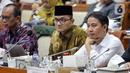 Dirjen Penyelenggaraan Haji dan Umrah (PHU) Hilman Latief (kanan) dan Kepala Badan Pengelola Keuangan Haji (BPKH) Fadlul Imansyah (tengah) menyampaikan paparan saat rapat dengar pendapat bersama Komisi VIII DPR di Kompleks Parlemen, Senayan, Jakarta, Selasa (14/2/2023). Pengumuman terkait besaran biaya haji terpaksa ditunda hingga besok lantaran pemerintah bersama Panja Komisi VIII DPR masih belum menemui kesepakatan. (Liputan6.com/Faizal Fanani)