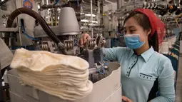 Seorang pekerja wanita saat berkerja di jalur produksi yang membuat kaus kaki pria di Pabrik Kaus Kaki Pyongyang di Korea Utara (24/5/2021). Pabrik ini memproduksi kaus kaki dengan menggunakan benang rayon Tetron domestik dan serat. (AFP/Kim Won Jin)