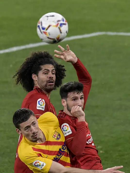 Bek Barcelona, Clement Lenglet berebut bola udara dengan dua pemain Osasuna, Jonathan Calleri dan Aridane pada pertandingan lanjutan La Liga Spanyol di stadion El Sadar di Pamplona, Spanyol, Minggu (7/3/2021). Barcelona menang atas Osasuna 2-0. (AP Photo/Alvaro Barrientos)