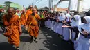 Murid sekolah dasar menyambut perjalanan rombongan 32 Biksu dari berbagai negara yang melakukan ritual Thudong dengan berjalan kaki menuju Candi Borobudur di Wiradesa, Kabupaten Pekalongan, Jawa Tengah, Kamis (25/5/2023). Ribuan warga menyambut perjalanan para biksu di sepanjang Jalan Pantura. (merdeka.com/Arie Basuki)