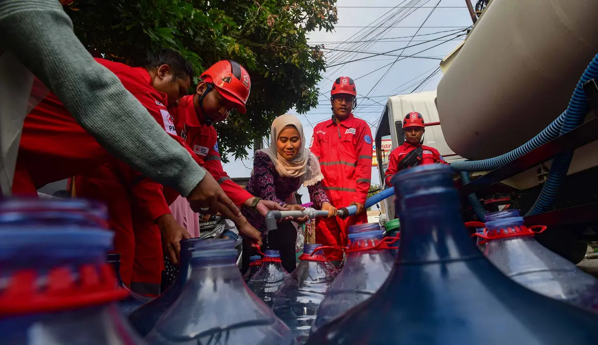 Petugas Palang Merah Indonesia (PMI) mengisi air bersih ke dalam galon air milik warga di RW 08. Cipayung Jaya, Kota Depok, Jawa Barat, Jumat (14/07/2026).