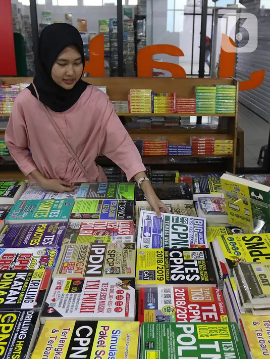 Pengunjung membaca buku panduan lolos tes CPNS di Pasar Kenari, Jakarta, Kamis (28/11/2019). Buku panduan lolos tes yang dijual mulai dari Rp 88.000 hingga Rp 195.000 per eksemplar menjadi barang yang paling dicari dan diminati jelang pelaksanaan tes CPNS. (Liputan6.com/Herman Zakharia)