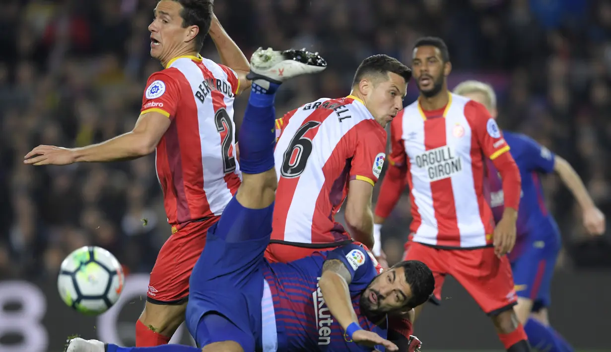 Aksi Luis Suarez melakukan tendangan salto saat berebut bola dengan para pemain Girona pada La Liga Santander di Camp Nou stadium, Barcelona, (24/2/2018). Barcelona menang telak 6-1. (AFP/Lluis Gene)