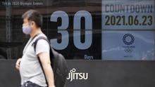 Seorang pria berjalan di depan kalender hitung mundur yang menunjukkan 30 hari menuju Olimpiade Tokyo 2020, di Tokyo, Rabu (23/6/2021). Olimpiade Tokyo dimulai pada 23 Juli dan penyelenggara mengizinkan penonton lokal menghadiri venue pertandingan dengan kapasitas 50 persen (AP Photo/Eugene Hoshiko)
