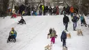 Anak-anak meluncur menuruni bukit saat mereka memanfaatkan salju tebal di taman Wilmersdorf-Schoeneberg di distrik Schoeneberg Berlin (8/2/2021). Hujan salju, hembusan angin kencang, dan suhu di bawah nol di utara dan Jerman bagian barat telah menyebabkan gangguan perjalanan. (AFP/ Odd Andersen)