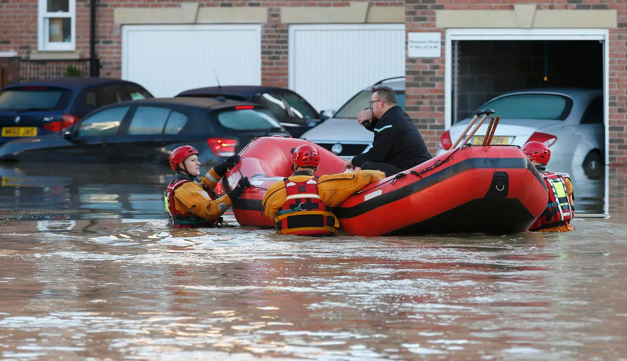 Petugas mengevakuasi warga yang terjebak banjir dirumahnya di York, Inggris utara, Minggu (27/12). Banjir akibat luapan sungai Ouse yang telah memperburuk sejumlah wilayah Inggris utara. (REUTERS/Phil Noble)