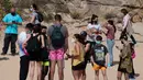 Orang-orang menikmati hari yang cerah di pantai Sa Conca di Castell-Platja D'Aro dekat Girona, Spanyol pada Rabu (31/3/2021). Masker telah wajib digunakan di Spanyol sejak Mei 2020 namun hanya di tempat yang tidak memungkinkan menjaga jarak minimal 2 meter. (Josep LAGO / AFP)