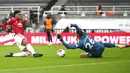 Penyerang Manchester United, Marcus Rashford, berebut bola dengan kiper Newcastle United, Karl Darlow, pada laga Liga Inggris di Stadion St. James' Park, Minggu (18/10/2020). MU menang telak dengan skor 4-1. (Owen Humpreys/PA via AP)