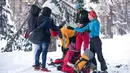 Turis Prancis menawarkan makanan dan minuman kepada para imigran dari Pantai Gading yang berjalan diatas salju untuk menuju perbatasan antara Italia dan Prancis di Pegunungan Alpen, Italia (13/1). (AFP/Piero Cruciatti)