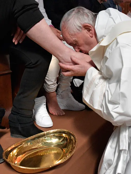Paus Fransiskus mencium kaki narapidana di penjara Paliano selama perayaan Kamis Putih, Italia (13/4). Pembasuhan kaki ini merupakan ritual penting dalam tradisi Gereja Katolik menandai Tri Hari Suci. (HO/OSSERVATORE ROMANO/AFP)