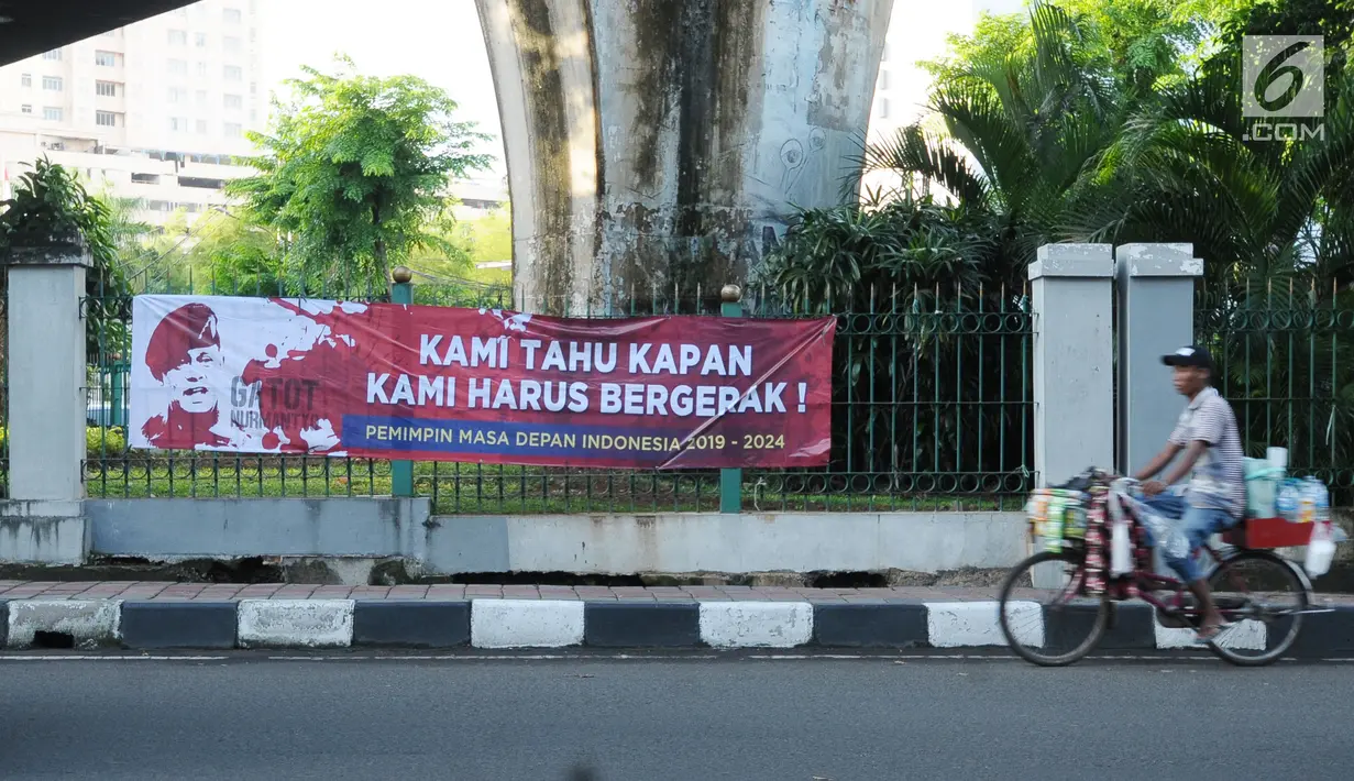 Pedagang melintas di sisi spanduk dukungan untuk Gatot Nurmantyo di kawasan Cikini, Jakarta, Minggu (1/4). Terdapat tulisan "Pemimpin masa depan Indonesia 2019-2024," pada spanduk yang tidak diketahui siapa pemasangnya. (Liputan6.com/Helmi Fithriansyah)