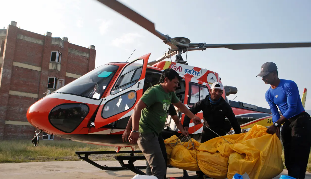 Jasad pendaki India yang tewas di  Everest diturunkan dari helikopter setibanya di ibu kota Nepal, Minggu (28/5). Jasad Ravi Kumar diterbangkan ke Kathmandu bersama dengan jasad dua orang lainnya yang meninggal tahun lalu. (AP Photo/Niranjan Shrestha)