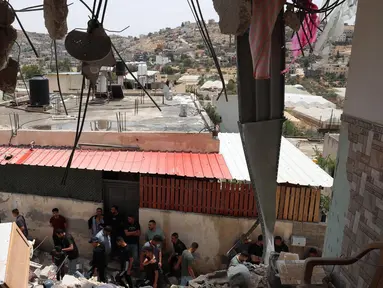 Warga Palestina memeriksa kerusakan di sekitar bangunan yang hancur setelah pasukan Israel mengepungnya di Tammun, Tepi Barat yang diduduki pada tanggal 15 Mei 2025. (Zain JAAFAR/AFP)