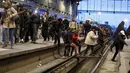 Para penumpang melintasi rel kereta di Stasiun Gare de Lyon, Paris, Prancis, Selasa (3/4). Aksi mogok massal akan berlangsung mulai 3 April hingga 28 Juni 2018. (AP Photo/Francois Mori)