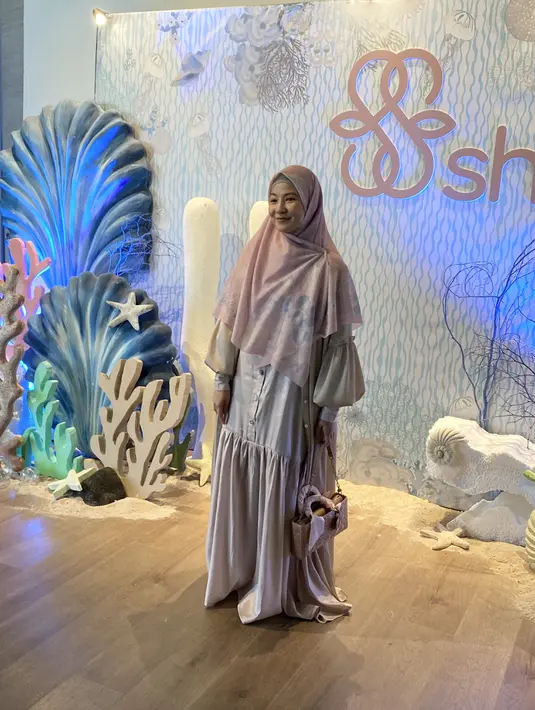 Natasha Rizki tampil dengan dress SHI yang flowy dipadukan outer lengan pump dan kerudung motifnya.