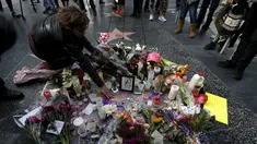 Penggemar meletakkan bunga di atas nama penyanyi legendaris David Bowie di Hollywood Walk of Fame di Los Angeles, Senin (11/1). Bowie meninggal di usianya yang ke 69 tahun dan baru saja merilis album ke-25 nya yaitu "Blackstar". (REUTERS/Mario Anzuoni)