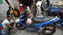 Seorang juru tambal usai memperbaiki motor pengendara yang terkena operasi cabut pentil,  Jakarta, Jumat (23/10/2015). Dengan tarif Rp3.000 para juru tambal mendapat banyak keuntungan. (Liputan6.com/Immanuel Antonius)