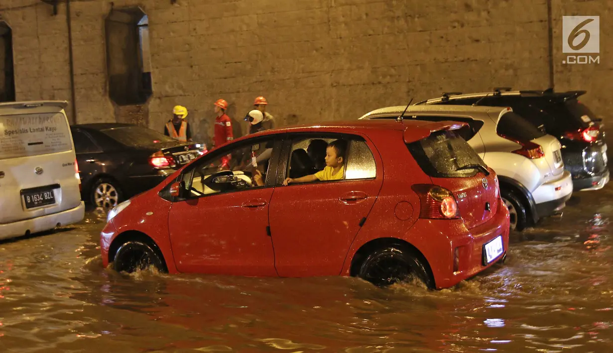 Kendaraan terjebak kemacetan di tengah banjir yang melanda terowongan (underpass) Cawang, Jalan MT Haryono, Jakarta, Selasa (12/12). Hujan deras yang mengguyur sebagian Jakarta mengakibatkan banjir di kawasan ini. (Liputan6.com/Herman Zakharia)