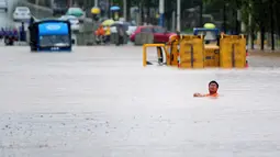 Seorang pria berjalan melewati banjir di Jiujiang , Provinsi Jiangxi , Cina , (19/2). Banjir yang tinggi menyendat lalu lintas Kota Jiujiang. (REUTERS/ China Daily)