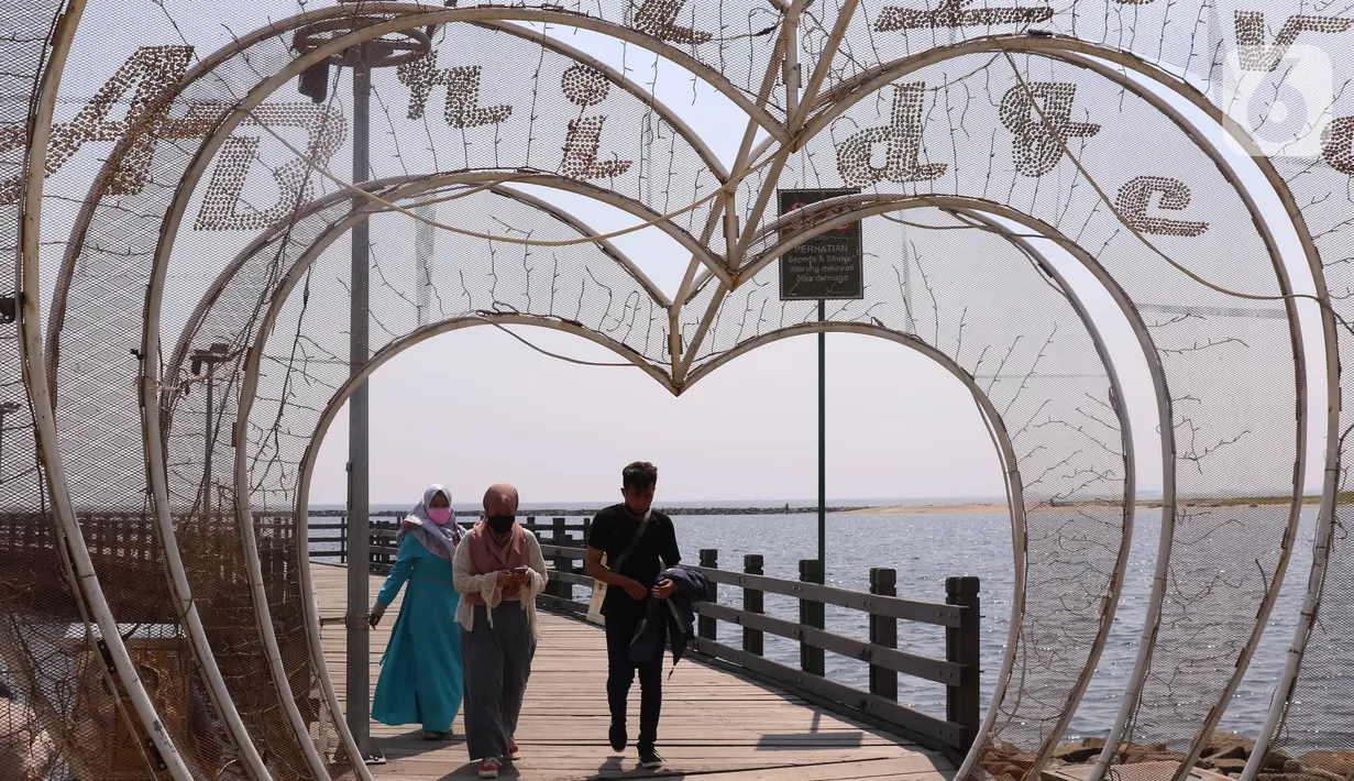 Pengunjung menikmati suasana Pantai Festival Taman Impian Jaya Ancol, Jakarta, Sabtu (20/6/2020). Setelah ditutup selama dua bulan akibat pandemi COVID-19, Kawasan rekreasi Taman Impian Jaya Ancol kembali dibuka. (Liputan6.com/Angga Yuniar)