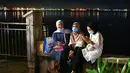 Sejumlah wanita bersantai di tepi perairan di Penang (1/8/2020). Malaysia tengah memperingatkan gelombang kedua virus corona COVID-19. (AFP Photo/Goh Chai Hin)