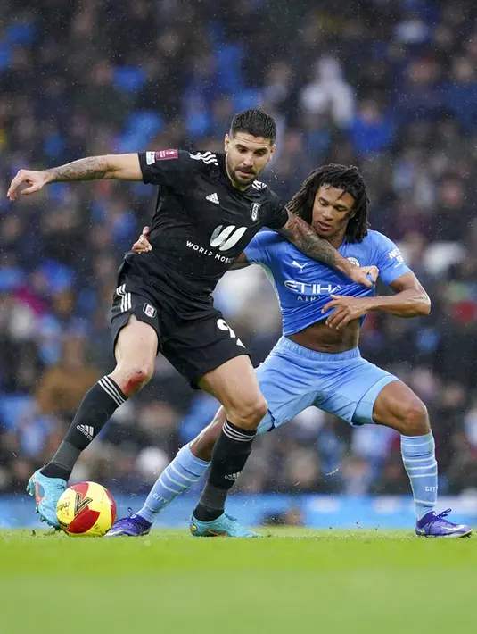 Pemain Fulham Aleksandar Mitrovic (kiri) berebut bola dengan pemain Manchester City Nathan Ake pada pertandingan sepak bola putaran keempat Piala FA di Etihad Stadium, Manchester, Inggris, 5 Februari 2022. Manchester City menang 4-1. (AP Photo/Jon Super)