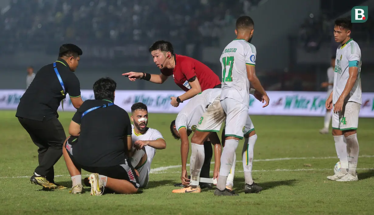 Wasit asal Jepang, Yusuke Araki, berbincang dengan tim medis saat memimpin pertandingan antara Persita Tangerang Vs Persikabo 1973 pada laga pekan ke-22 BRI Liga 1 2023/2024 di Stadion di Indomilk Arena, Tangerang, Minggu (10/12/2023). Persita menang dengan skor 2-1. (Bola.com/M Iqbal Ichsan)