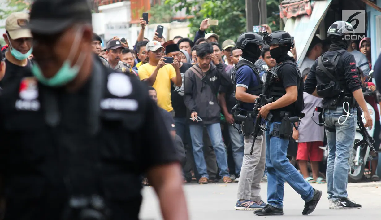 Warga antusias menyaksikan penggerebekan terduga teroris oleh Densus 88 Antiteror Mabes Polri di Jalan Gempol Raya, Kunciran Indah, Tangerang, Banten, Rabu (16/5). Warga dilarang mendekati lokasi saat penggerebekan terjadi. (Merdeka.com/Istimewa)
