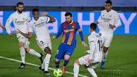 Striker Barcelona, Lionel Messi dikepung pemain Real Madrid pada lanjutan Liga Spanyol 2020/2021 dalam laga bertajuk El Clasico, Minggu (11/4/2021) dini hari WIB. (JAVIER SORIANO / AFP)