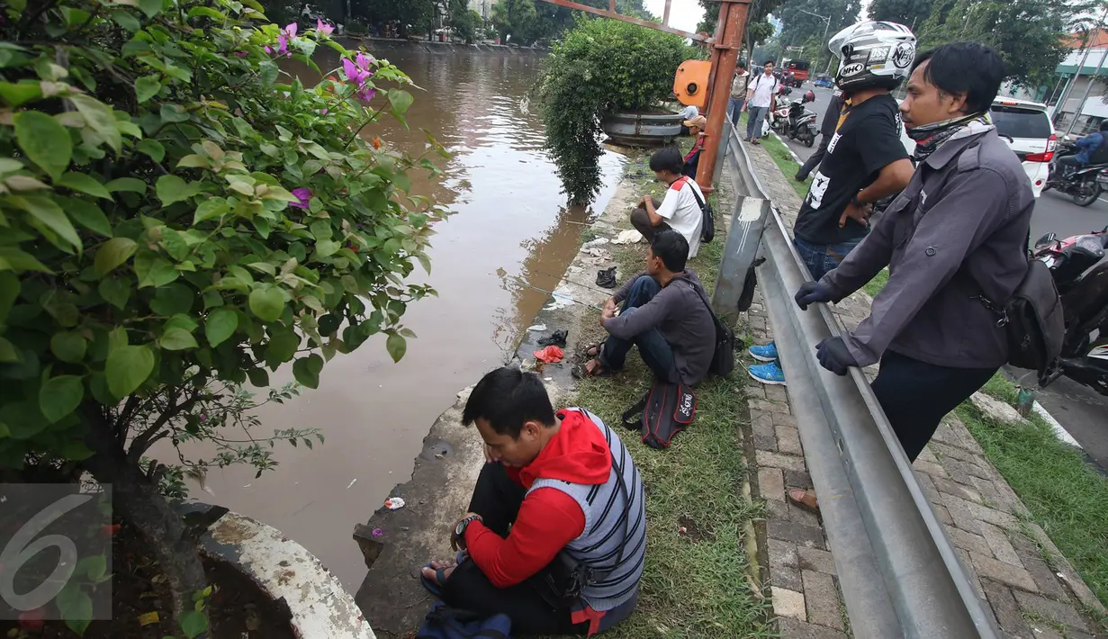 Sejumlah warga memancing ikan di bantaran Sungai Ciliwung, Jakarta, Selasa (21/2). Meluapnya Sungai Ciliwung menjadi berkah tersendiri bagi warga untuk memancing dan menjala ikan yang terbawa arus dari hulu. (Liputan6.com/Immanuel Antonius)