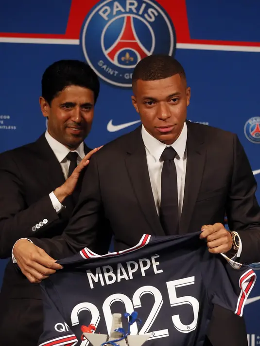 Striker Paris Saint-Germain (PSG) Kylian Mbappe (kanan) menunjukkan jerseynya dengan Presiden PSG Nasser Al-Khelaifi saat konferensi pers di Stadion Paris des Princes, Paris, Prancis, 23 Mei 2022. Keputusan Kylian Mbappe menolak Real Madrid dan berkomitmen untuk PSG selama tiga musim lagi menandai dimulainya proyek pembangunan klub juara Liga Prancis tersebut. (AP Photo/Michel Spingler)