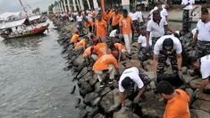 Prajurit Pusat Hidrografi dan Oseanografi TNI AL bersama petugas keamanan Ancol membersihkan sampah di sepanjang Pantai Ancol, Jakarta, Selasa (22/1). Kegiatan itu dilakukan mulai dari Pantai Lagoon hingga dermaga Marina. (Merdeka.com/Iqbal S. Nugroho)