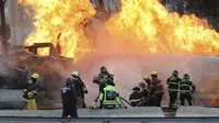 Petugas pemadam kebakaran menyemprotkan air ke sebuah truk tangki gas yang meledak di bawah jembatan layang jalan tol di Mexico City, Meksiko, Rabu (10/9/2025). (Dok. AP Photo/Tristan Velazquez)
&nbsp;